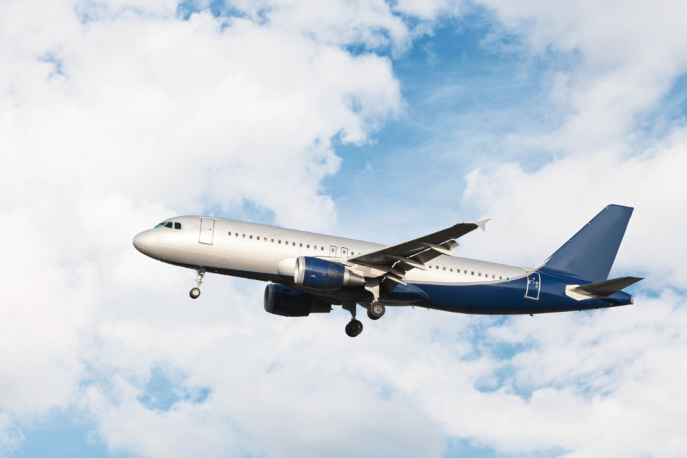 A flying cargo plane against a blue sky